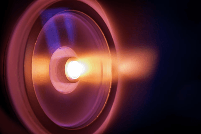 A cilinrical entrance shows the flow of hot plasma glowing orange