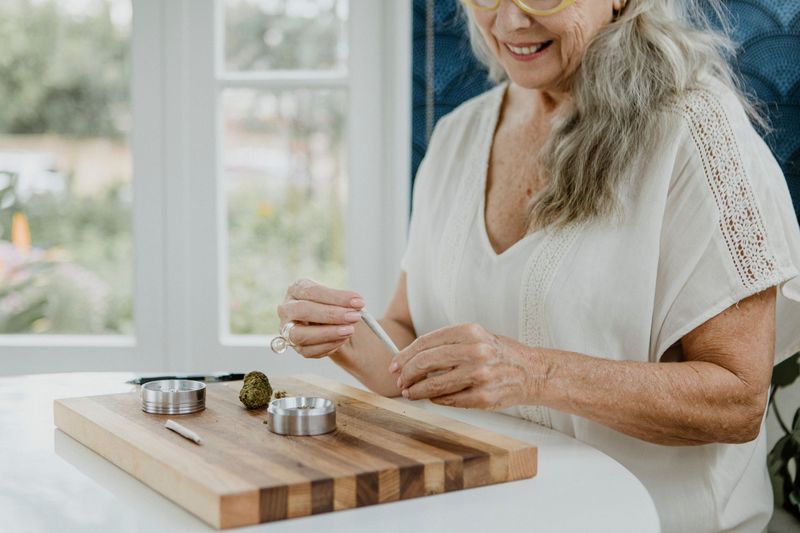 older woman rolling a cannabis joint