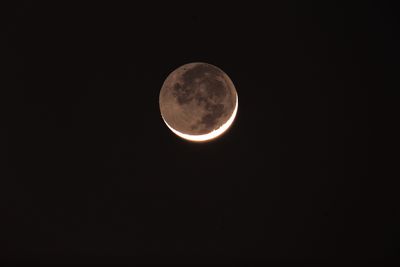 The round Moon at night with onlya sliver lit up to show the New moon, but you can also the the res of the m=Moon faintly it with what is called Earthshine 