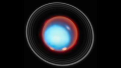 the image show the planet uranus with its rings visible. four bright splotches are visible onf the planet, the aurorae.