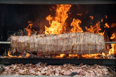 kebab being cooked on a spit over a wood fire