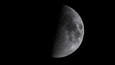A photo of the waxing first quarter of the Moon. Half of the moon is illuminated, with the dark matria clearly visible.
