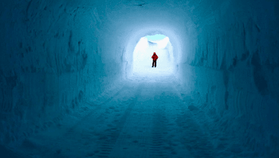 A figure stands at the opening of the Ice Memory Foundation's glacial storage cave in Antarctica.