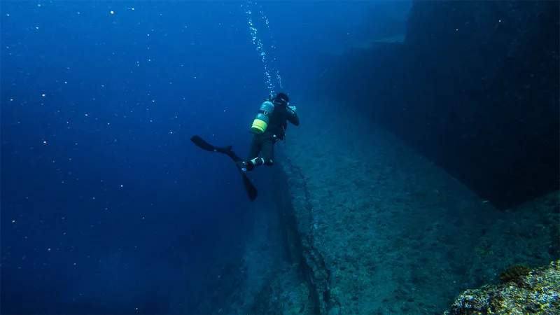 A diver at Yonaguni Monument. Rocks resembling steps underneath the sea.