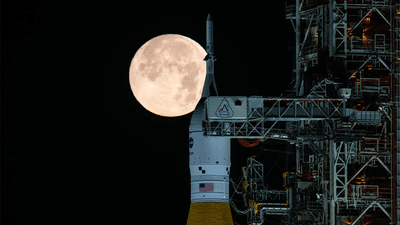 NASA's Space Launch System (SLS) rocket with the Moon in the background.