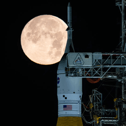 NASA's Space Launch System (SLS) rocket with the Moon in the background.