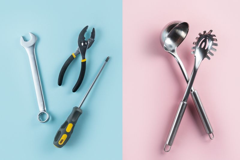 representation of traditional gender roles; left panel has a wrench, pliers, and screwdriver on a blue background; right panel has a ladle and spaghetti spoon on a pink background