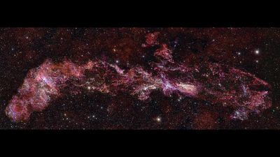 This image shows the complex distribution of molecular gas in the Central Molecular Zone, very wispy and filimentary, over a busy background filled with stars.