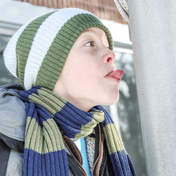 A boy about to stick his tongue to a frozen lamppost.