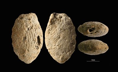 A butterfly clay bead from the Final Natufian period in Eynan-Mallaha (Upper Jordan Valley), colored red with ochre and marked with the fingerprints of the child