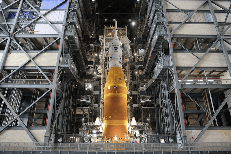 The top of the rocket is visible among the scaffolding of the vehicle assembly building