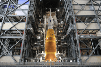 The top of the rocket is visible among the scaffolding of the vehicle assembly building