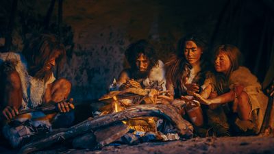 A Neanderthal family gathere around a fire with some kind of animal cooking over the fire.  