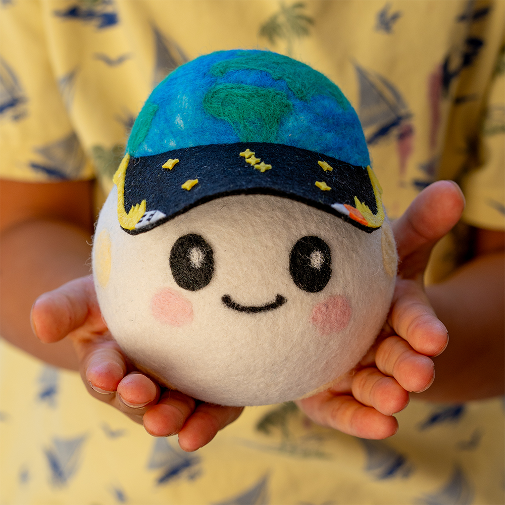 A plushie ball with a face drawn on, and a hat depicting the Earth and stars. A plushie ball with a face drawn on, and a hat depicting the Earth and stars.