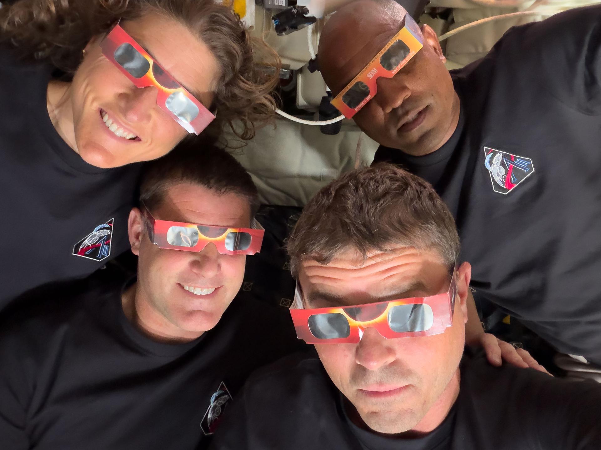 a selfie of the four astronauts donning eclipse glasses