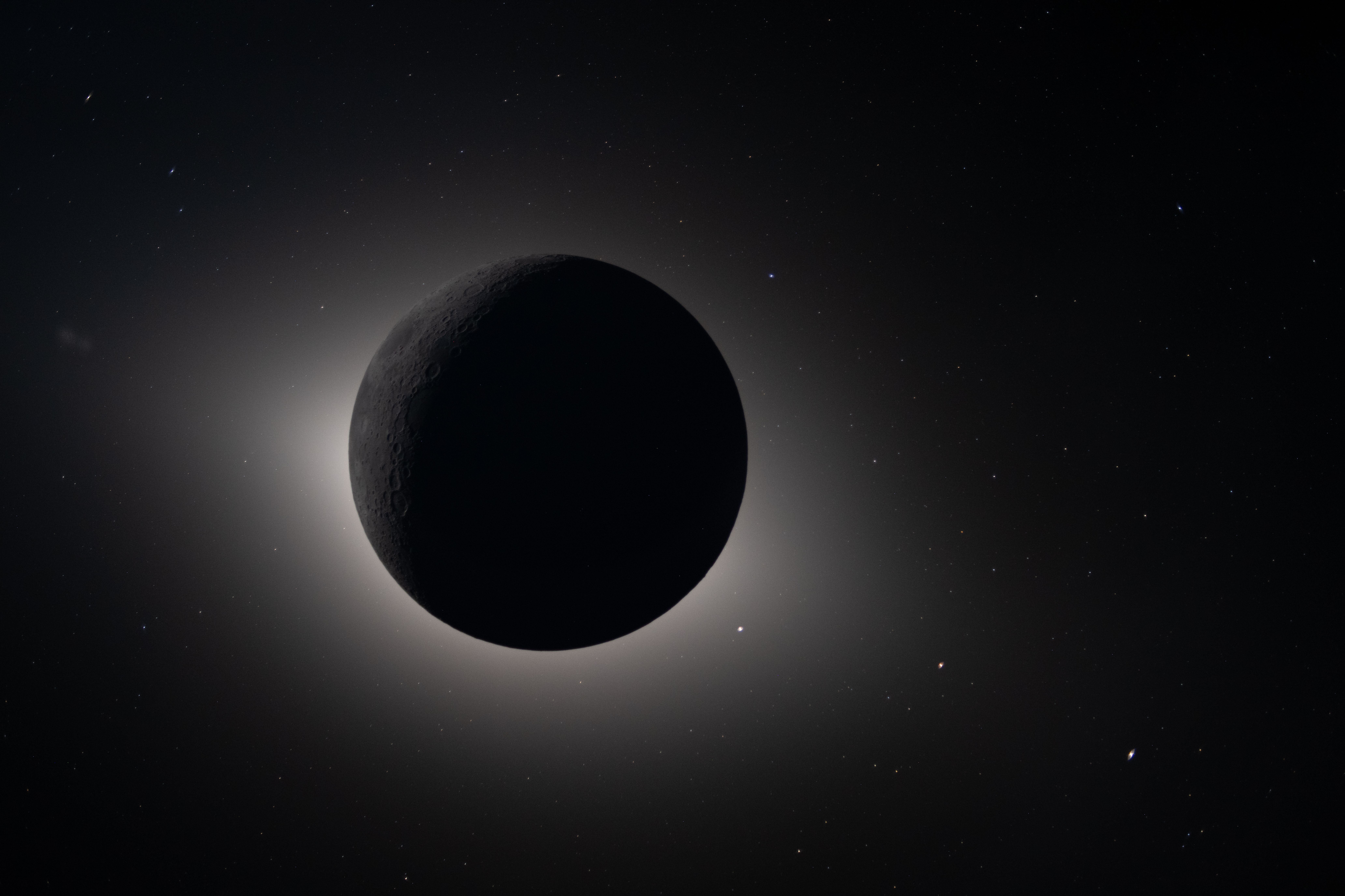 the moon blocking the Sun glowing back lit. Stars and planet are visible as bright dots around the Moon the moon blocking the Sun glowing back lit. Stars and planet are visible as bright dots around the Moon
