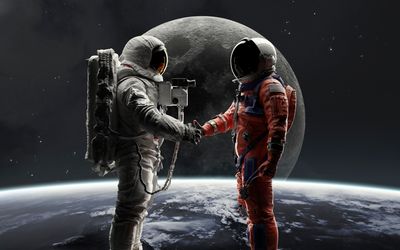 Two astronauts stand in front of the Moon shaking hands, one in and Apollo-era suit and one in an Artemis-era suit