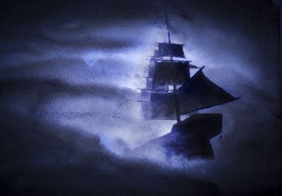The silhouette of a Ghost Ship in a hazy fog sails through the sea