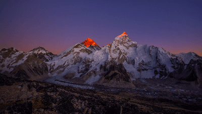 Mount Everest at sunset, with the peak glowing red.