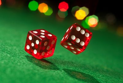 A pair of dice being cast over a green mat