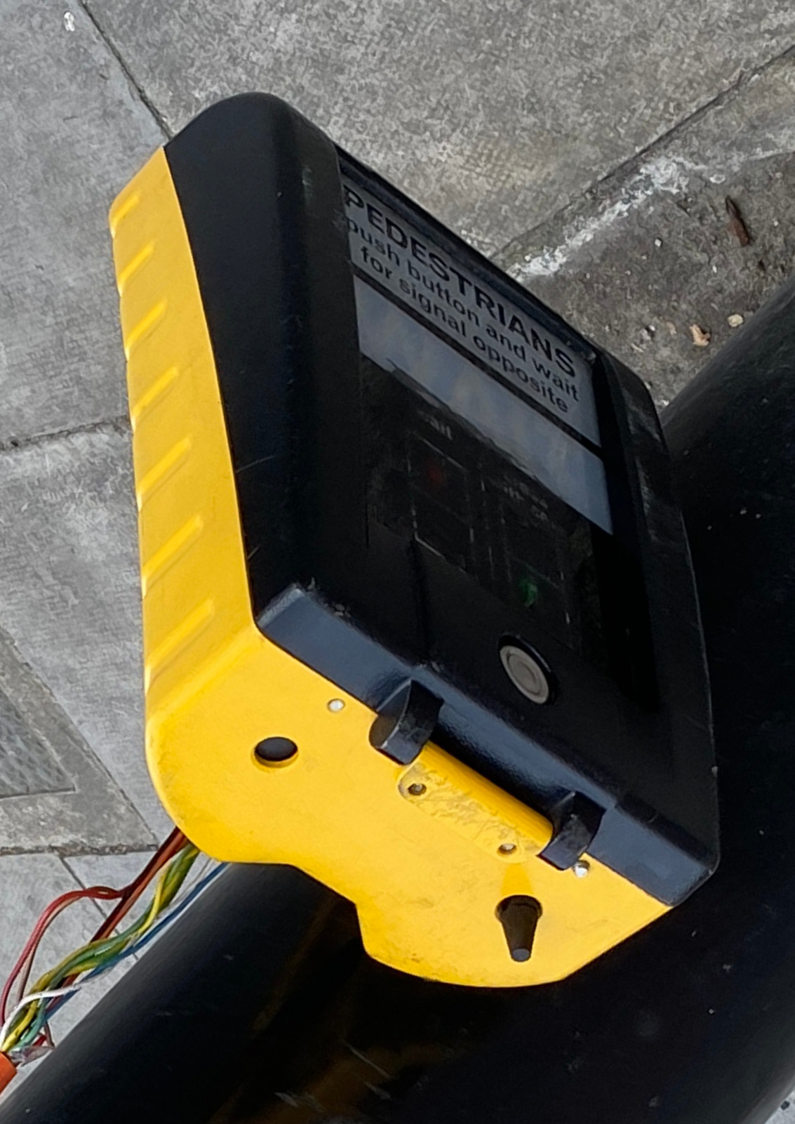UK pelican crossing box shown from underneath with a small rotating cone tactile device protruding from it