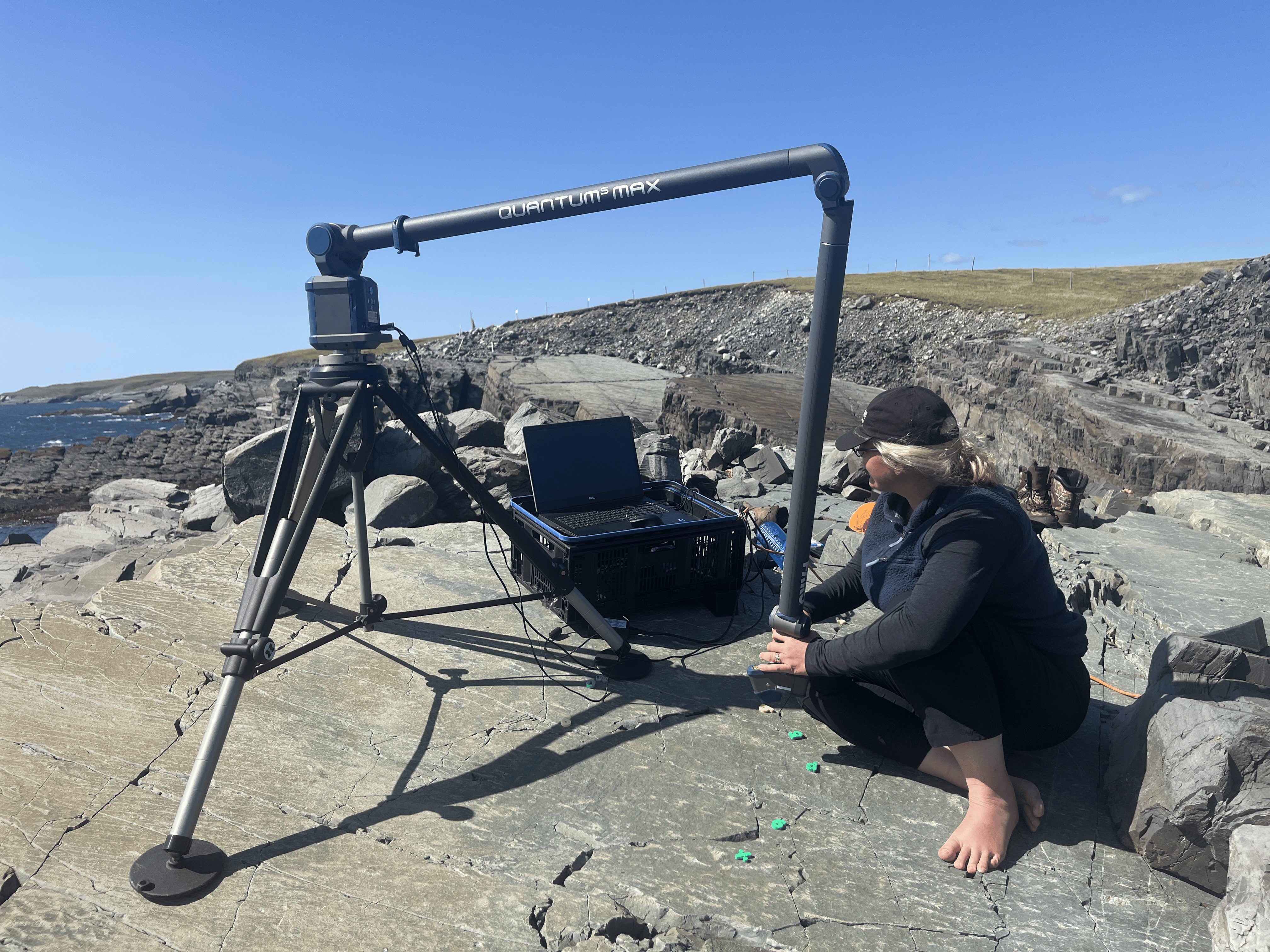 Dr Emily Mitchell at Mistaken Point, Newfoundland, Canada scans fossils from the region, with a large machine mounted on a tripod and connected to a laptop. Dr Emily Mitchell at Mistaken Point, Newfoundland, Canada scans fossils from the region, with a large machine mounted on a tripod and connected to a laptop.