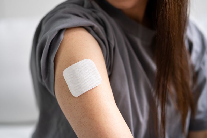 white patch stuck on woman's upper arm