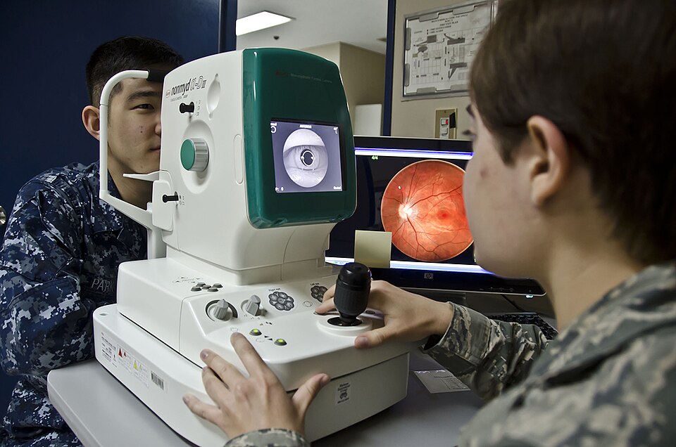A man is having an eye test, with the back of his retina visible on a screen. 