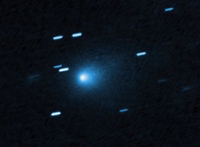 the comet is fuzzy with no major tail. distant stars appear as line instead of dots as the telescope moved to track the comet
