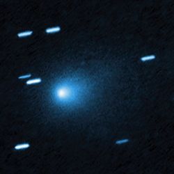 the comet is fuzzy with no major tail. distant stars appear as line instead of dots as the telescope moved to track the comet