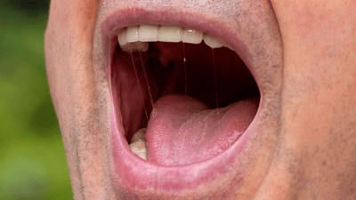 Close up of a man's mouth, yelling.