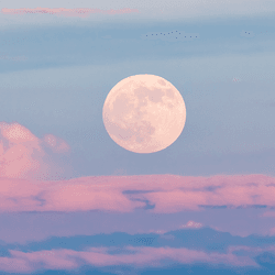 The Moon, above some clouds.