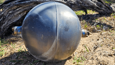 A large metal sphere on an Australian beach.
