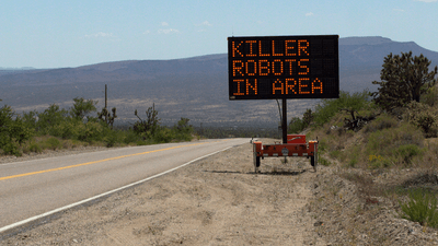 A sign along a road reading "killer robots in area".