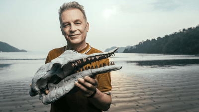 chris packham holds the replica skull of Simocetus rayi, an ancient early toothed whale.