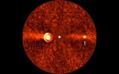 A grainy image show a bright round source a and a much fainter fuzzy one on the opposite side of a covered star