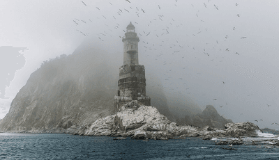 Mist and seabirds hang over the Aniva lighthouse in the North Pacific Ocean near Sakhalin, Russia.