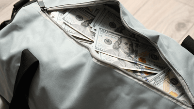 an open bag filled with dollar notes