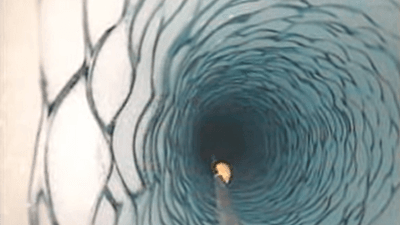 a little orange blob clings to a cable deep inside a hole drilled into ice