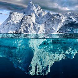A large iceberg, which can be seen above and reflected in the water.