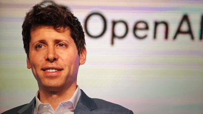 OpenAI CEO Sam Altman, in front of a sign which reads "OpenAI".