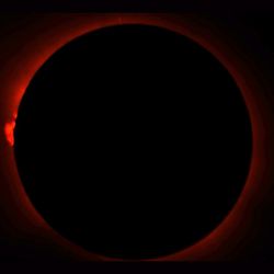 On the left: A gorgeous photo of the eclipse, with the Sun glowing red behind the Moon, and a visible solar prominence on the left of the Moon. On the right: A terrible eclipse-shaped shadow, projected onto the inside of a car door.