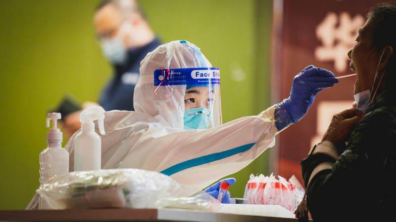 person in full protective gear taking a swab for a COVID test