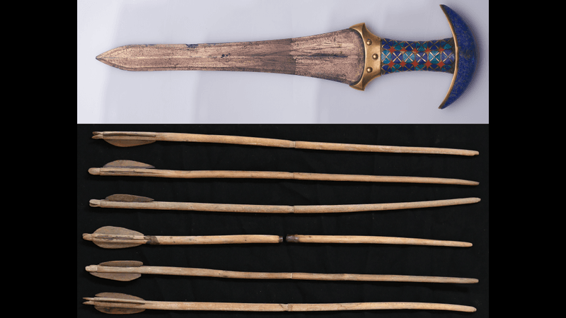 a dagger with an ornate blue handle and a row of arrows