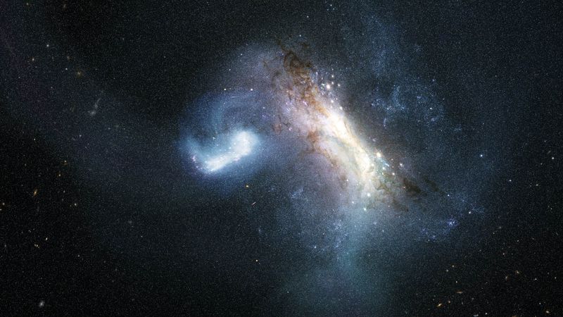 A small bright galaxy is colliding with a much larger one