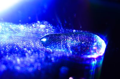 a water droplet on the surface of a cd with light shingin through it showing funky little refractions