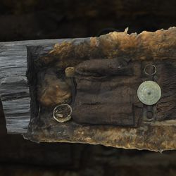 A picture of the Egtved Girl burial as it now is, showing the furs and clothing within a log coffin.