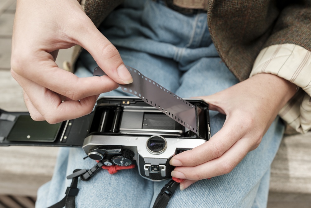 Someone loading a film into an analogue camera Someone loading a film into an analogue camera