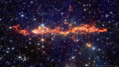 the background of the image is filled with stars. In the center a large, mostly stright jet that looks like flames is visible. smaller jets criss cross this one.
