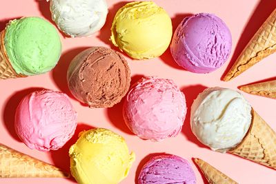 variety of ice cream scoops and cones on a pink background